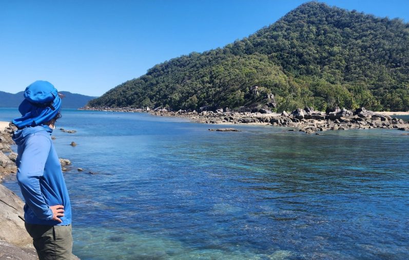 A person overlooking a wide, crystal-clear river in nearby protected parks: Cahuita, Tortuguero, or Gandoca-Manzanillo.